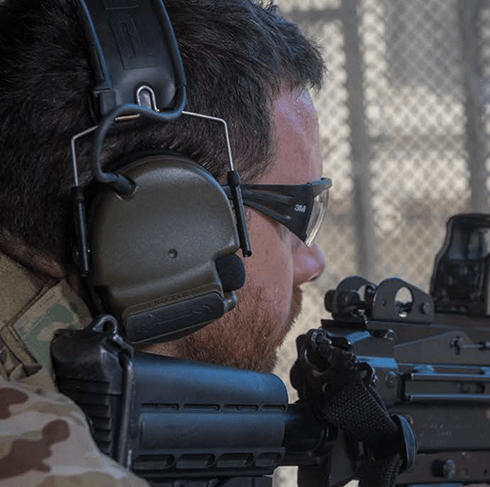 Man wearing ComTac VI NIB Headset on tan mesh background